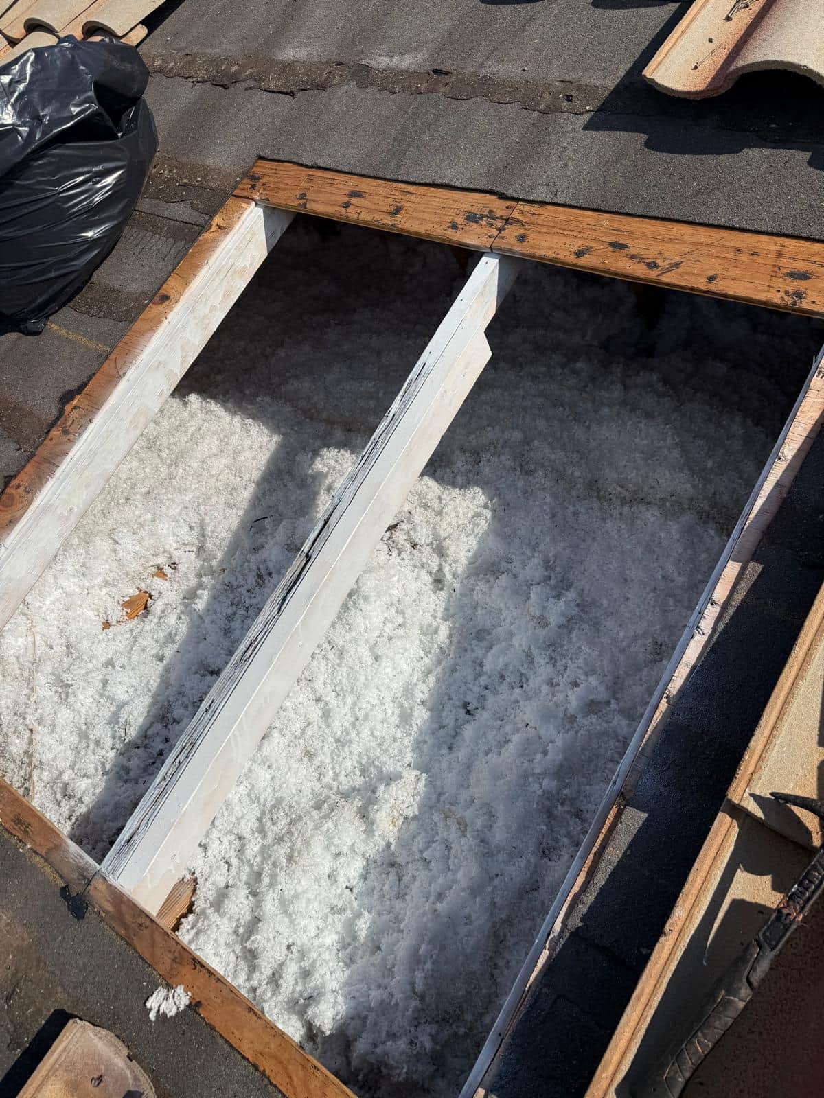 Open tile roof cavity exposing rafters and insulation